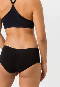 Schwarzer Sport-BH im Stil mit hohem Taillenslip aus glattem Material. Verfügt über ein Racerback-Design und einen elastischen Bund für Unterstützung und Komfort.