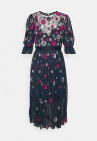 Marinblå tylklänning med blommiga paljettdekorationer i rosa, silver och blått. Har puffärmar och en smal midjedetalj.