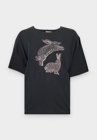 Black cotton t-shirt with loose fit, featuring a graphic print of two rabbits in white and light purple on the front. Short sleeves and crew neckline.