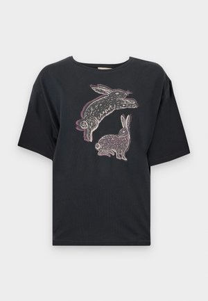 T-shirt nera in cotone con vestibilità ampia, caratterizzata da una stampa grafica di due conigli in bianco e lilla chiaro sul davanti. Maniche corte e scollatura rotonda.