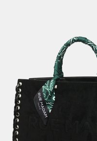 Borsa a tracolla nera in suede con dettagli di pizzo laterali, manico in tessuto avvolto in una sciarpa di stoffa a motivo verde, e un'etichetta con la scritta "RUE MADAM PARIS."