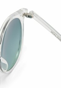 Gafas de sol con montura transparente y lentes degradados verdes, con una bisagra plateada y un logotipo en relieve en la varilla.