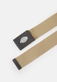 Bruine geweven stoffen riem met een zwarte rechthoekige metalen gesp waarop het Dickies-logo staat. Het ontwerp is eenvoudig zonder aanvullende patronen.