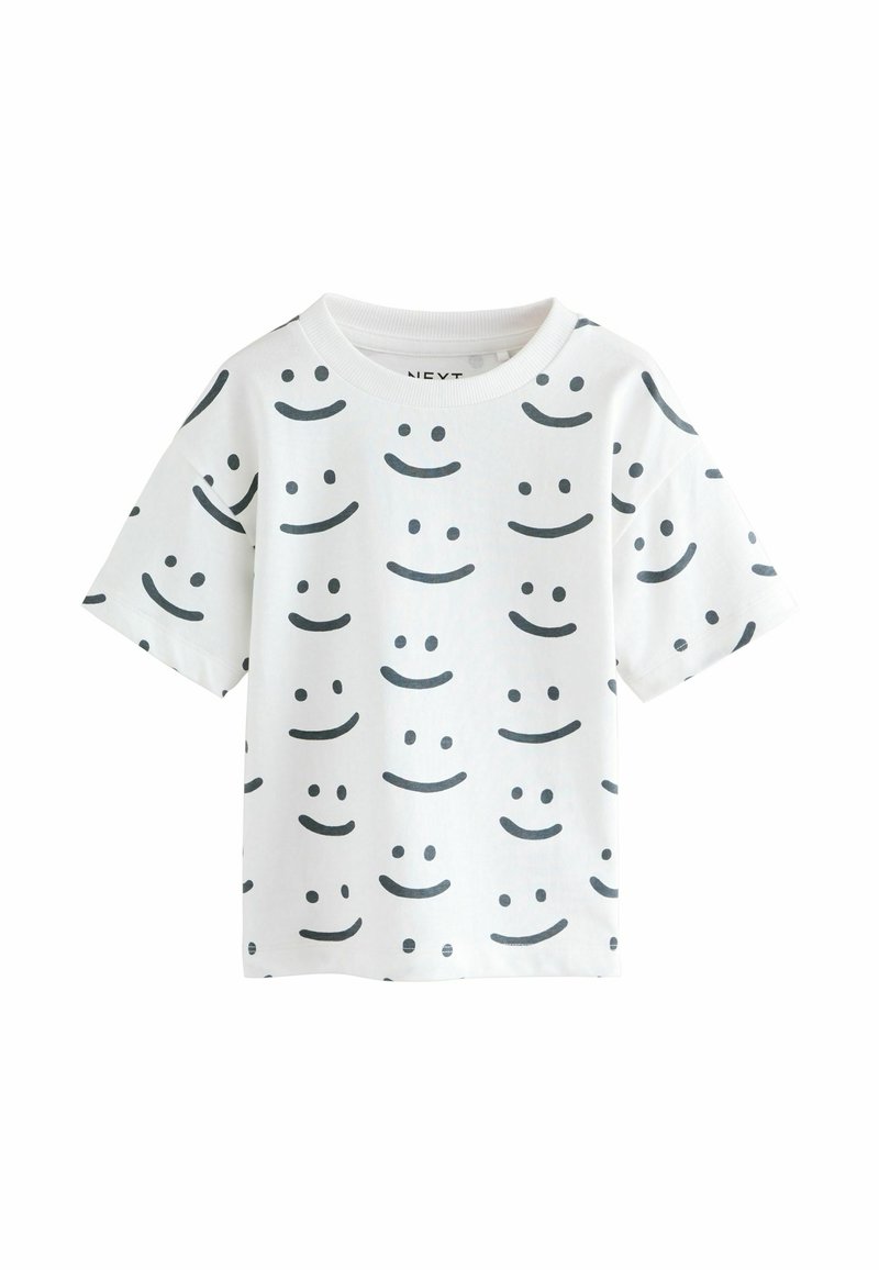 Hvid kortærmet t-shirt lavet af bomuld, med sorte smileyansigt mønstre i forskellige positioner, rund halsudskæring og en afslappet pasform.