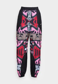 Pantalones atléticos de colores y patrones con cintura elástica, que presentan colores negro, rosa, rojo y marrón, además de diseños gráficos audaces.