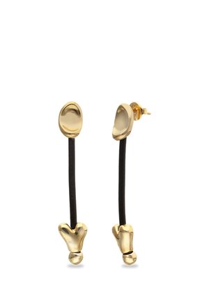 Boucles d'oreilles à tiges dorées avec des formes irrégulières reliées par de fines tiges noires, vues de face et de côté sur un fond blanc.