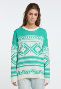 Mėlynos ir baltos spalvos megztinis su geometriniais raštais, apvaliu kaklu ir ilgomis rankovėmis su iškiliais kraštais. Minkšta tekstūra.