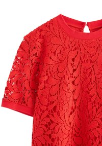 Rød kortærmet kjole med blomsterlacet overlay og solid stof underlag, der har en rund halsudskæring med ribbet trim og knaplukning bagpå.