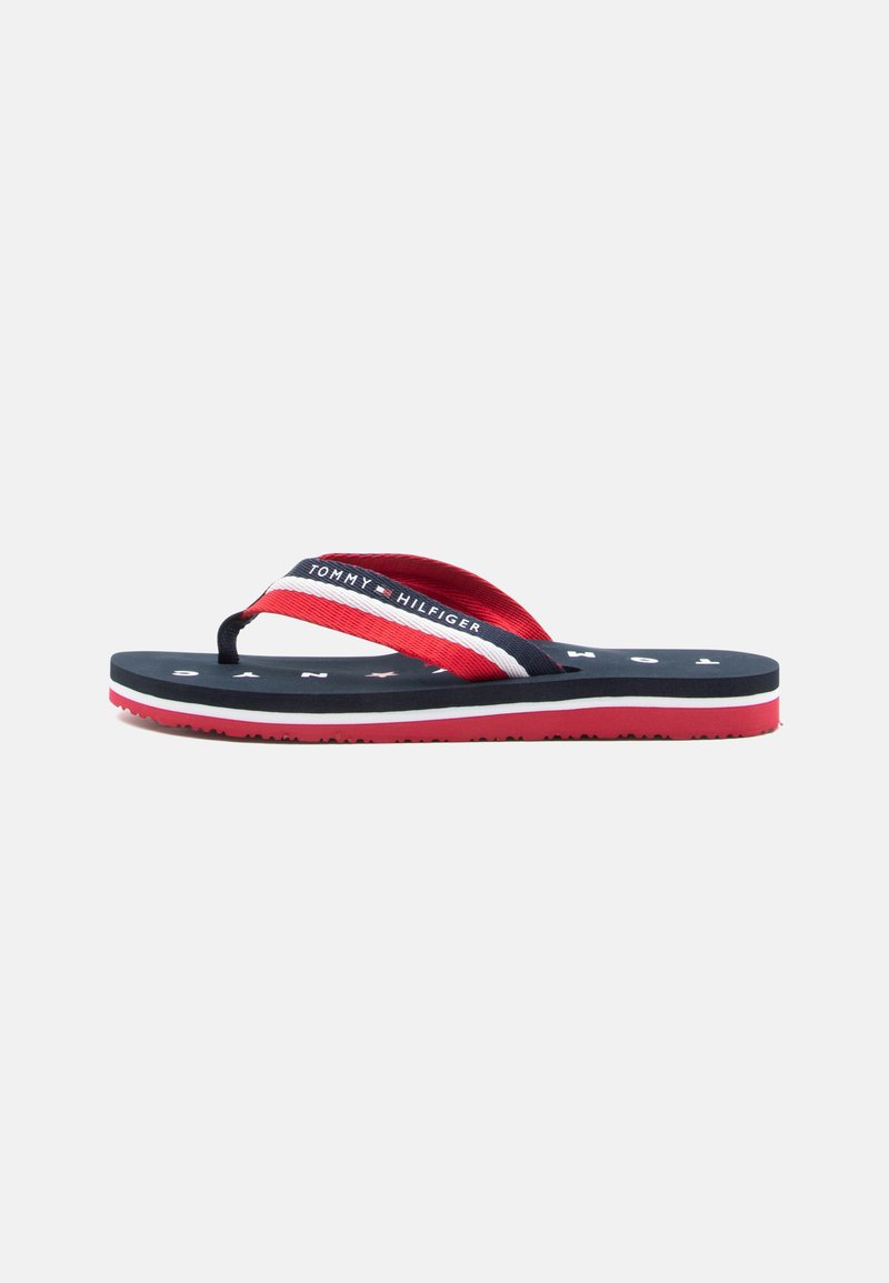 Flip-flop sandal med en marineblå såle, røde og hvite striper på stroppene, og en teksturert rød yttersåle. Har "Tommy Hilfiger" branding.