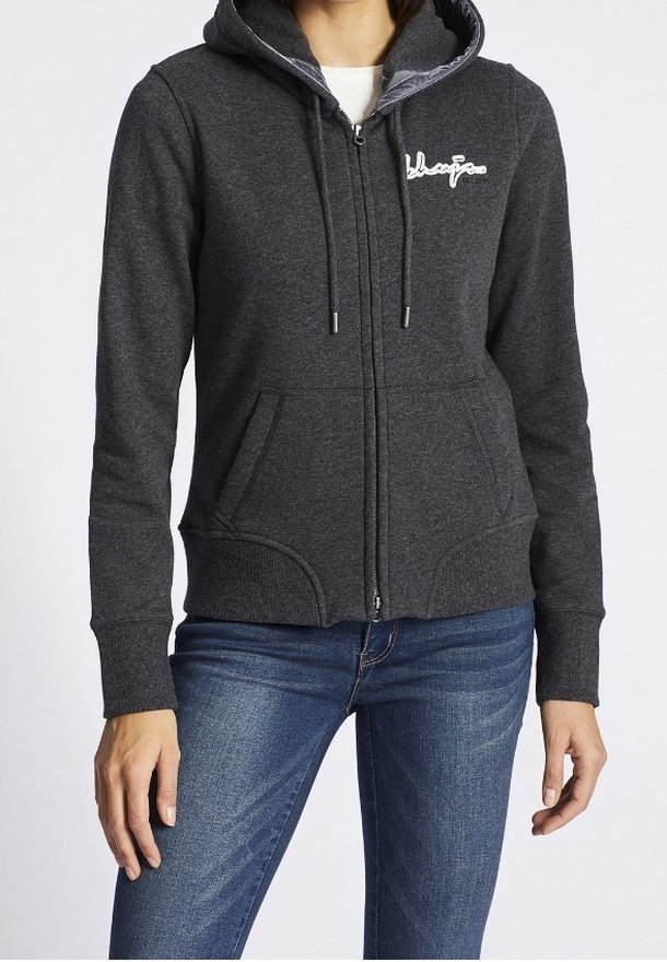 Sudadera con capucha gris oscuro con cremallera, capucha con cordón, bolsillos delanteros y un detalle de logo en blanco. Tela suave, diseño ajustado y puños acanalados.