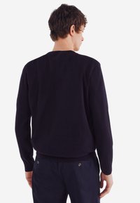 Marineblauer Rundhalsausschnitt-Pullover mit langen Ärmeln, aus einem glatten Strickstoff gefertigt. Verfügt über einen gerippten Saum und Bündchen; schlichtes Design ohne Muster.