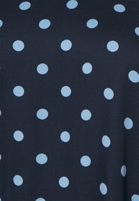 Tissu navy avec des pois bleu clair dans un motif uniforme. La texture semble lisse et légèrement texturée. Les pois sont répartis de manière homogène.