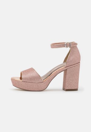 Roze glitter platform sandalen met een open teen, enkelbandje en een blokhak. Kenmerkt een metallic gouden accent op de zool.