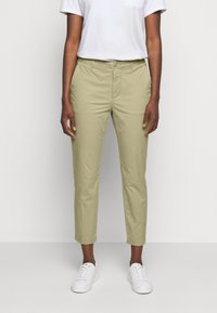 Ljus olivgröna byxor med slim fit, som har sidfickor, knappstängning och uppvikta nederdelar, i kombination med vita sneakers.