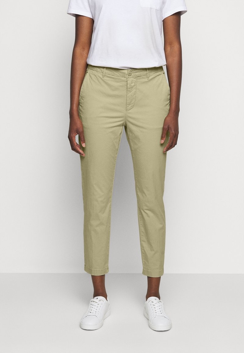 Ljus olivgröna byxor med slim fit, som har sidfickor, knappstängning och uppvikta nederdelar, i kombination med vita sneakers.