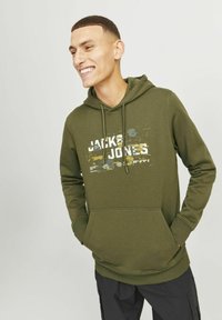 Olijfgroene hoodie met een voorzak in kangoeroestijl, een capuchon met trekkoord en een contrasterende grafische print in wit en aardetinten.