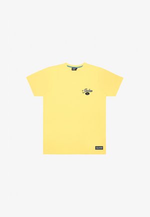 Žlté bavlnené tričko s krátkymi rukávmi, okrúhlym výstrihom, malým čiernym logom na hrudi a etiketou na dolnom leme.