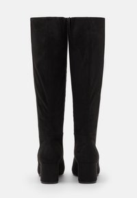 Botas negras hasta la rodilla en suave ante, con tacón cuadrado y cremallera trasera para facilitar su uso. Textura lisa con líneas limpias y elegantes.