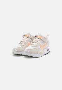 Bež Nike Air Max tenisice s mrežastim i kožnim materijalima, sa narančastim logotipom, podstavljenim ovratnikom i vidljivim zračnim jastučićem u potplatu.