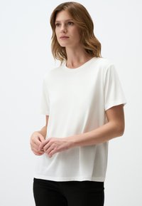 Witte katoenen T-shirt met korte mouwen en een ronde hals. Gladde textuur, comfortabele pasvorm en geen zichtbare patronen of accenten.