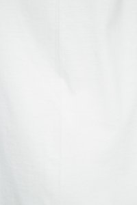 Tejido de algodón blanco con una textura suave, que presenta sutiles arrugas y pliegues. Diseño minimalista sin patrones ni acentos visibles.