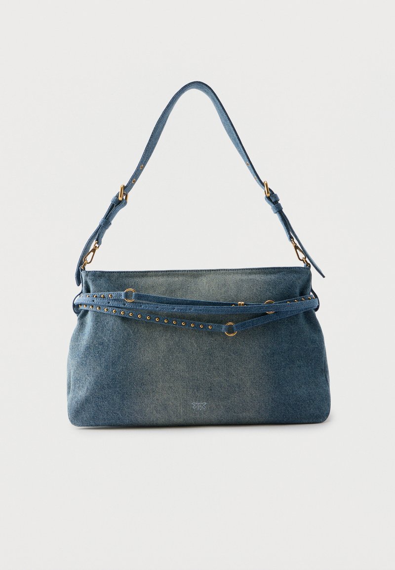 Μπλε τζιν τσάντα ώμου με ρυθμιζόμενο ιμάντα και μεταλλικά καρφιά και δακτύλιοι σε χρυσό τόνο, σε απλό λευκό φόντο.