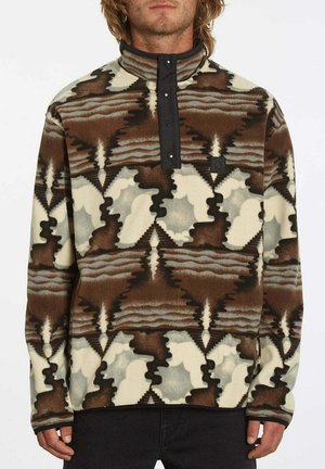 Fleece-Pullover mit hohem Kragen, versehen mit einem geometrischen Muster in Braun, Creme und Grau, Druckknopfverschluss und einem Logopatch auf der Brust.