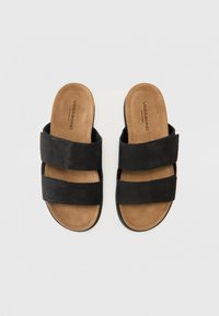 Black slide sandals with two wide matte straps, soft tan footbed, and a textured sole for grip. Branding visible on the footbed.