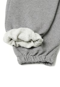 Šedá mikina s rukávem se staženým manžetem. Světle šedá, texturovaná pletenina na zápěstí. Měkký, hladký materiál po celé délce.