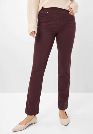 Burgunderfarbene Slim-Fit-Hosen mit dehnbarem Bund und Vordertaschen, kombiniert mit beigen spitzen Ballerinas. Baumwollstoff mit glatter Textur.