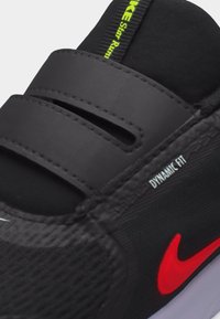 Μαύρο αθλητικό παπούτσι Nike με κόκκινο λογότυπο, λουράκια με βέλκρο, κείμενο «Dynamic Fit» και νέον πράσινη ετικέτα «Nike Star Run» στη γλώσσα.