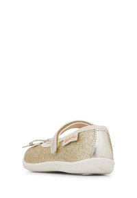 Złote błyszczące buty Mary Jane z metalicznym paskiem i detalem w postaci kokardy, białą podeszwą, materiałem przypominającym skórę oraz markową metką z boku.