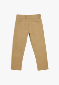 Chinos de algodón color beige, diseño de pierna recta, dos bolsillos traseros y cintura sin costuras. Textura suave y acabado limpio.