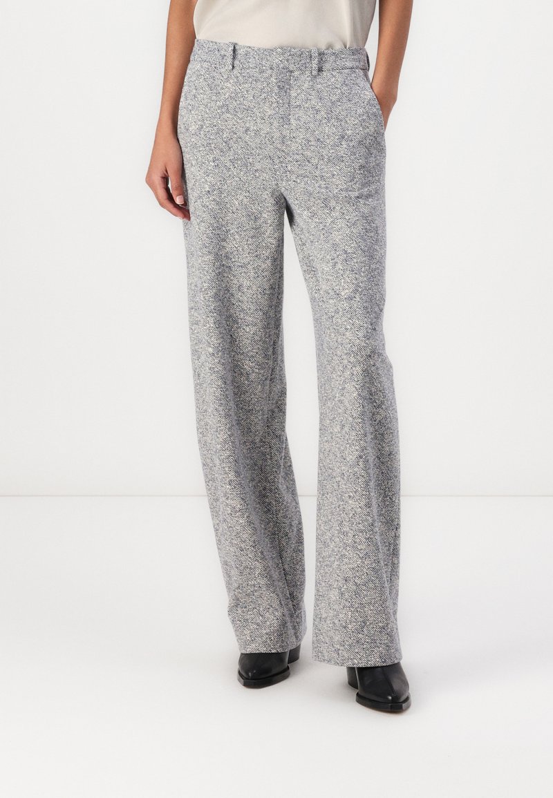 Pantalons larges texturés gris clair avec un motif en chevrons et des passants de ceinture. Dotés de poches latérales et d'une coupe droite, adaptés à diverses occasions.