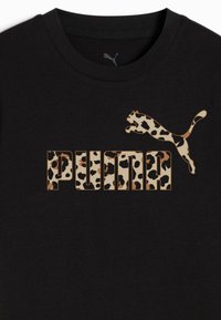 Črna bombažna majica s kratkimi rokavi, ki vsebuje velik leopardji vzorec "PUMA" logotipa in grafiko skočnega leoparda v svetlo rjavi in črni barvi. Okrogla izreza.