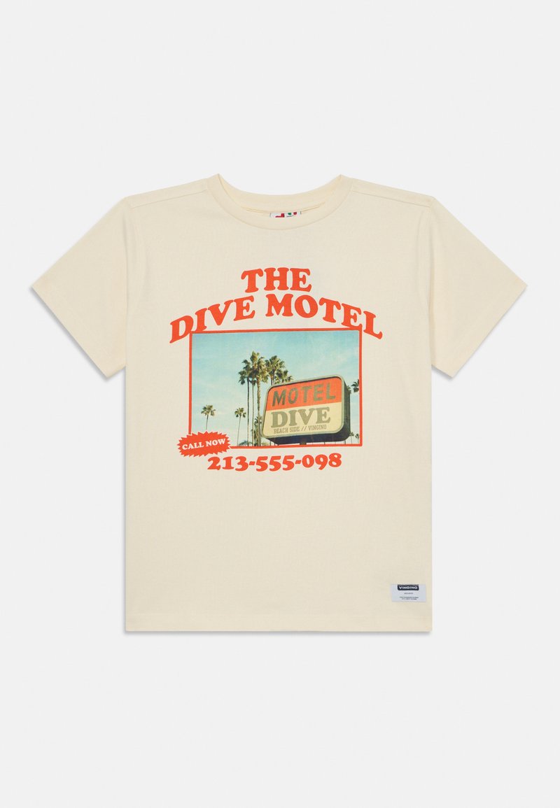 Krēmkrāsas kokvilnas T-krekls ar krāsainu "Dive Motel" grafiku, kurā attēloti palmu koki, sarkana teksta un kontaktinformācija. Parasts piegriezums, apaļais kakls.
