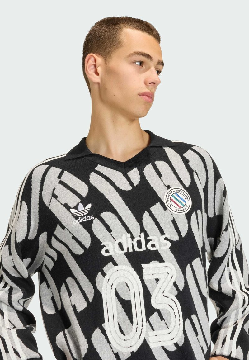 Maglietta a maniche lunghe con colletto, con motivo nero e grigio, con logo "adidas", numero "03" e una toppa rotonda sul petto.