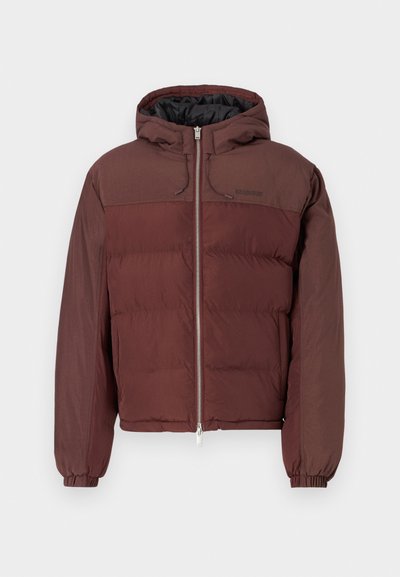 Μπορντό φλις τζάκετ με κουκούλα, ελαστικούς καρπούς και φερμουάρ μπροστά. Διαθέτει συνδυασμό λείων και καπιτονέ υφασμάτων.