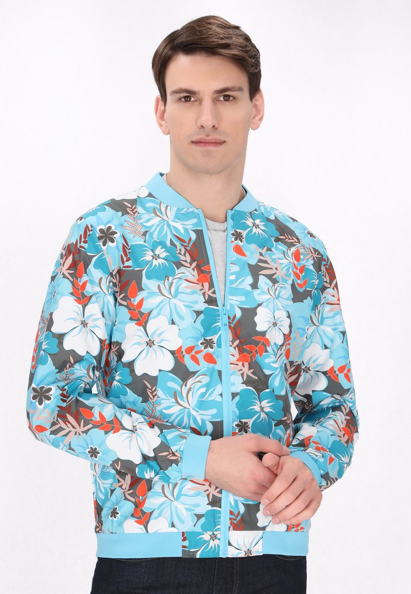 Giacca bomber floreale in blu e grigio con un vivace motivo di fiori bianchi e arancioni, dotata di zip frontale e polsini a costine.