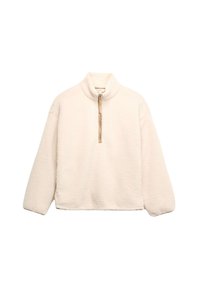 Polarowy pulower w kolorze kremowym z wysokim kołnierzem i krótkim zamkiem. Posiada fakturowaną powierzchnię i obniżone ramiona dla luźniejszego kroju.
