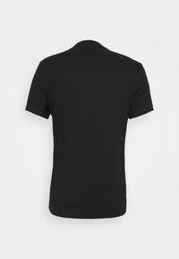 Camiseta de algodón negra con mangas cortas, cuello redondo y una textura suave. Vista trasera, sin estampados ni logotipos visibles.