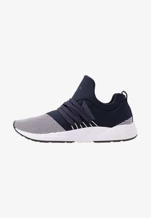 Herren schwarzer und weißer texturierter Slip-On-Sneaker mit dicken Schnürsenkeln, gepolsterter weißer Sohle und Zuglasche an der Ferse.