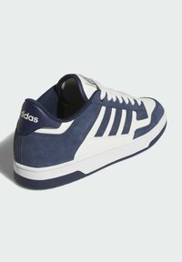 Zapatillas en azul marino y blanco con materiales de ante y cuero, con cordones blancos, tres franjas en el lateral y una suela de goma texturizada.