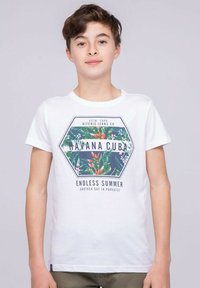 T-shirt en coton blanc avec un graphique hexagonal coloré représentant des plantes tropicales et le texte : "Havane Cuba Été sans fin." Manches courtes, col rond.