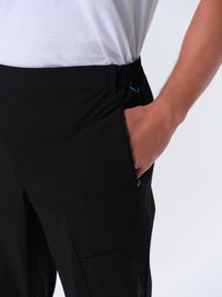 Schwarze Hose mit einem elastischen Bund, seitlichen Taschen und einer Cargo-Tasche. Verfügt über eine glatte Stofftextur mit einem dezenten Glanz.