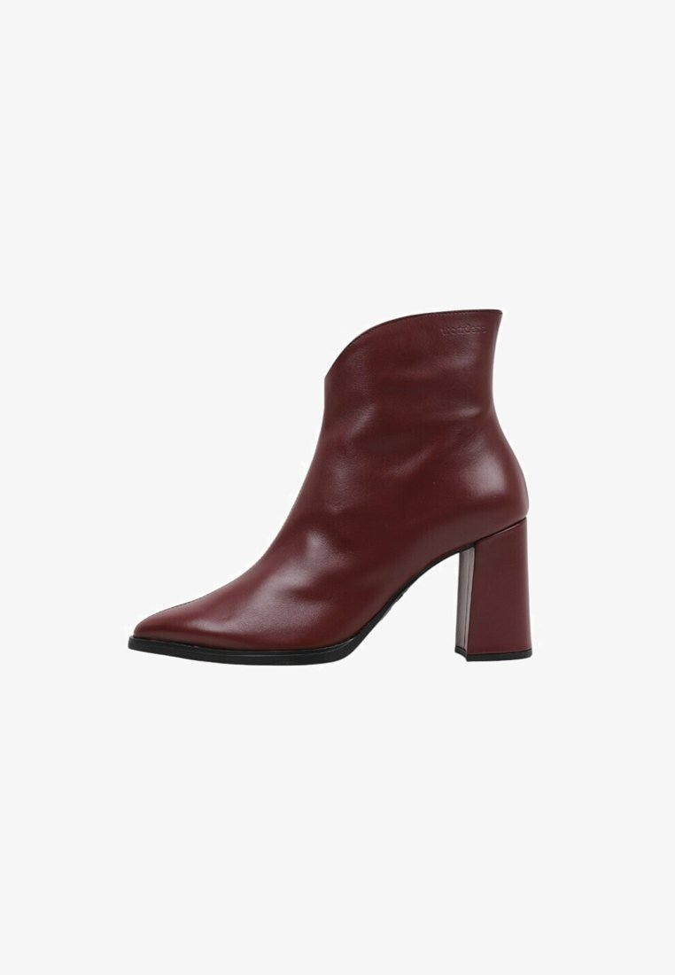 Botín de cuero burdeos con punta afilada, línea superior curvada y tacón grueso, que presenta una textura suave y un diseño minimalista.