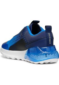 Zapatillas deportivas que presentan una mezcla de materiales azul oscuro y azul claro, un diseño hexagonal texturizado y una suela azul translúcida.