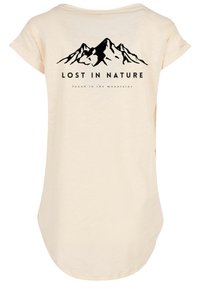 Light beige t-shirt with a relaxed fit, featuring a black mountain graphic and the text "LOST IN NATURE" printed on the back.