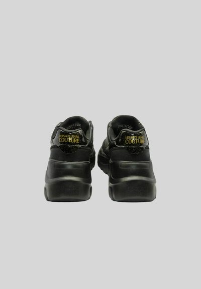 Sneaker nere con tomaia in tessuto testurizzato, tallone rinforzato e suola in gomma. Presenta un logo dorato sul retro e un design elegante e moderno.