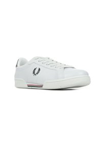 Sneaker in pelle bianca con punta tonda, logo in rilievo sul lato e strisce orizzontali rosse e blu sulla suola.